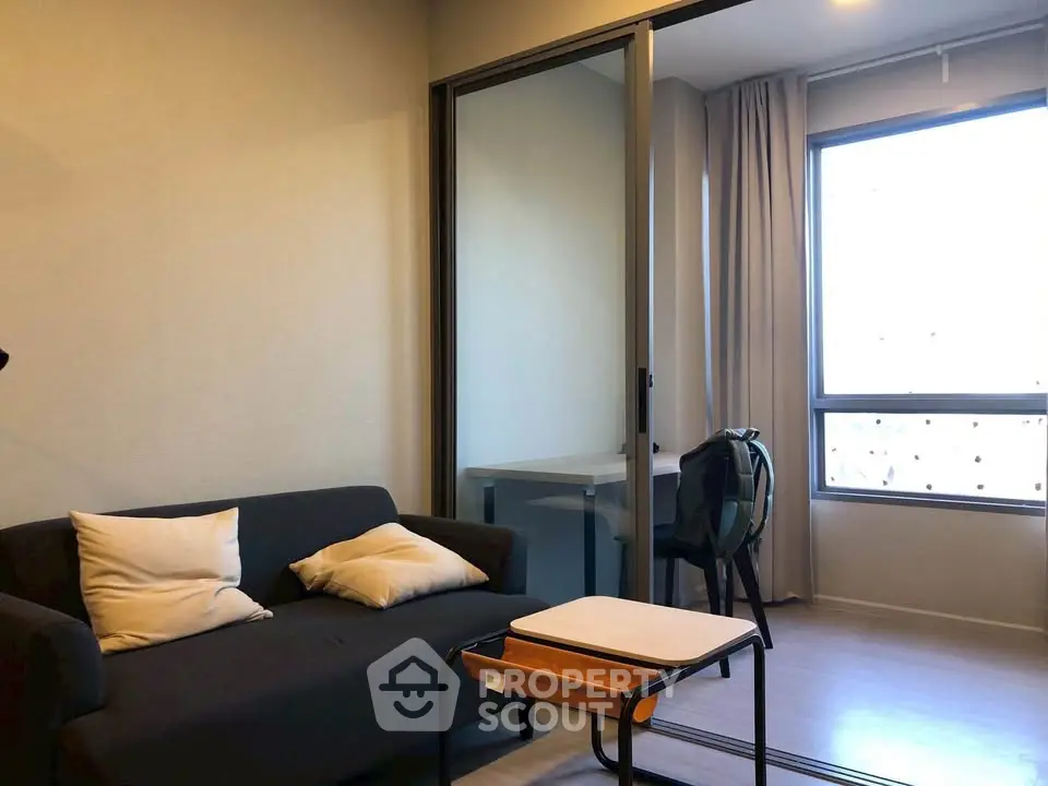 Modern living room with cozy sofa and large window for natural light.