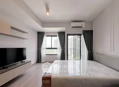 Modern bedroom with large window and city view, featuring sleek furniture and air conditioning.