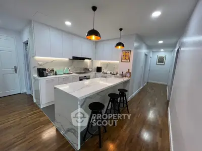 Modern kitchen with marble island and pendant lighting in sleek apartment