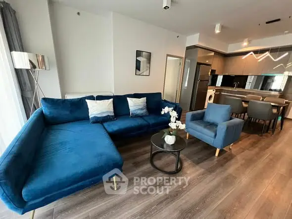 Modern living room with blue sofa and open kitchen layout