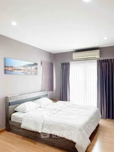 Modern bedroom with large bed, stylish decor, and natural light