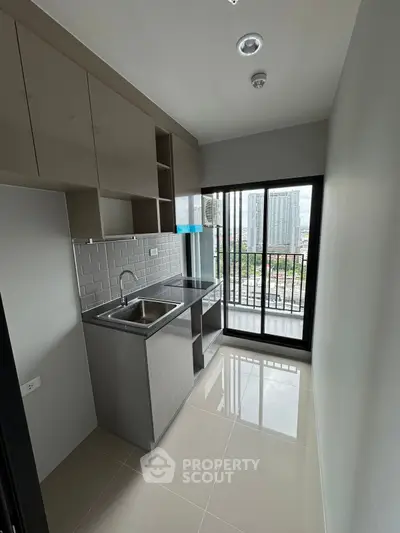 Modern compact kitchen with sleek cabinetry and city view balcony