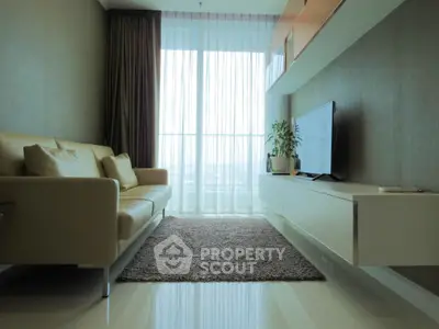 Modern living room with sleek furniture and large window view.