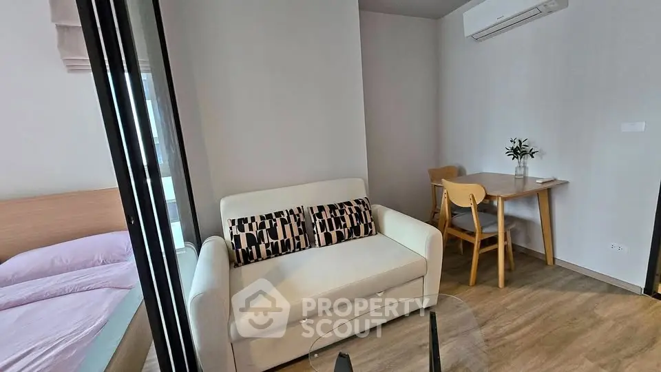 Modern studio apartment with cozy living area and dining space, featuring stylish furniture and air conditioning.