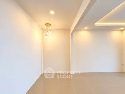 Spacious modern interior with elegant lighting and sleek tile flooring, perfect for customization.