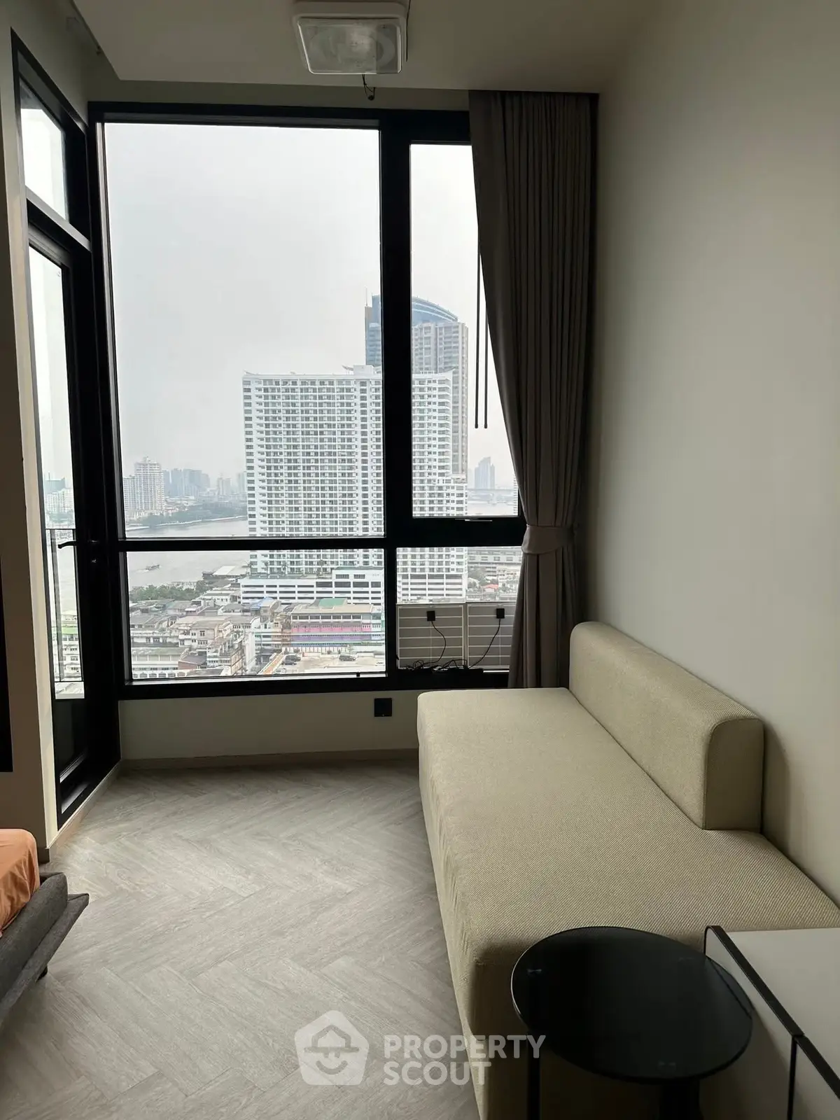 Modern living room with large window offering stunning city view