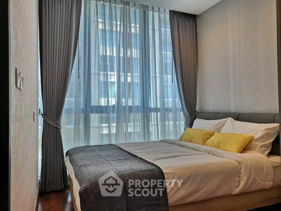 Modern bedroom with large window and elegant curtains in a high-rise apartment.