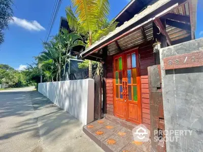 Charming wooden entrance with colorful glass panels and tropical landscaping