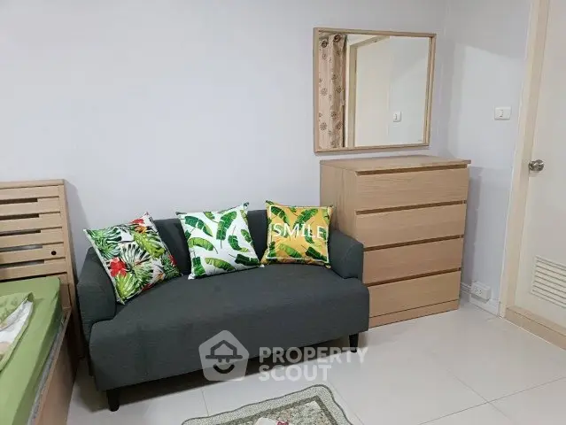 Cozy bedroom with stylish sofa and dresser, perfect for relaxation and comfort.