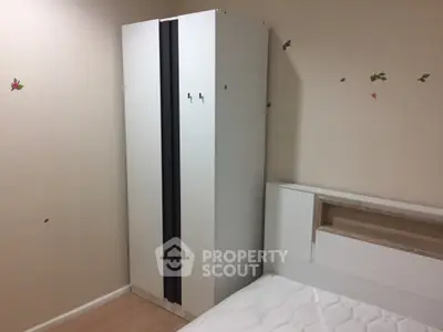 Cozy bedroom with modern wardrobe and comfortable bed, adorned with playful butterfly stickers, perfect for restful nights in a compact urban home.