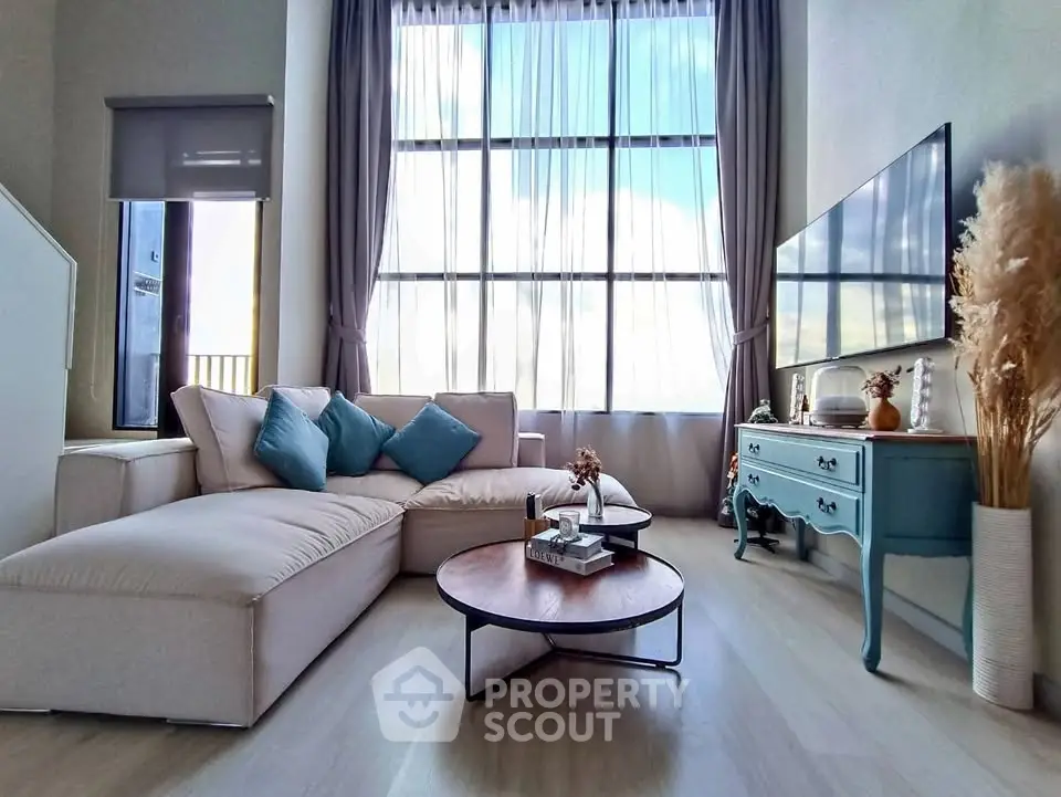 Spacious living room with modern decor and large windows offering natural light.