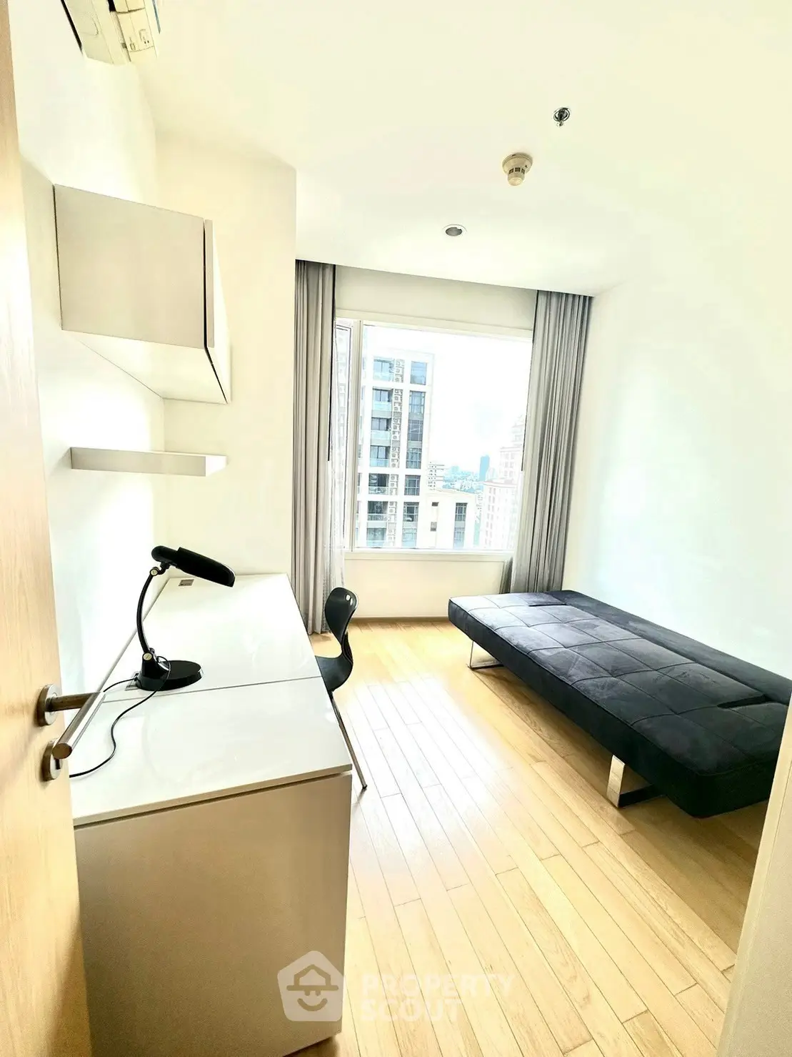 Modern study room with desk, chair, and city view from window