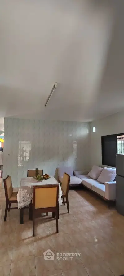 Spacious living room with dining area and modern furniture in a cozy home setting.