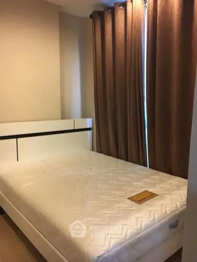 Cozy bedroom with a comfortable mattress and elegant curtains, perfect for restful nights.