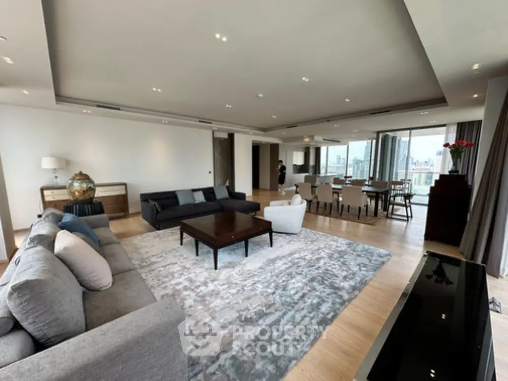 Spacious modern living room with open layout and city view, featuring elegant furniture and stylish decor.