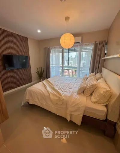 Spacious bedroom with modern decor and large window offering city views, perfect for urban living.