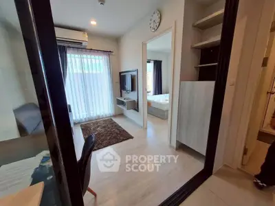 Modern apartment interior with living room and bedroom, featuring sleek design and natural light.