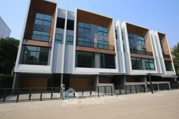 Modern townhouse exterior with large windows and balconies
