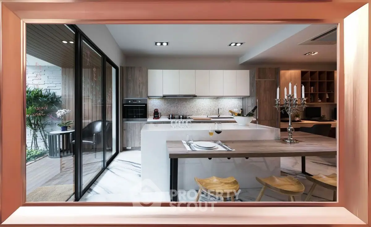 Modern kitchen with open layout and stylish dining area, featuring sleek cabinetry and elegant decor.
