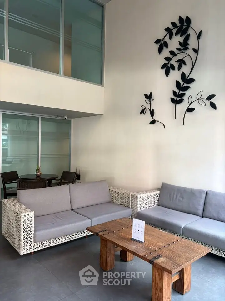Modern lobby with stylish seating and artistic wall decor in a contemporary building.
