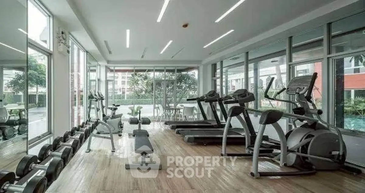 Modern gym with state-of-the-art equipment and large windows offering natural light.