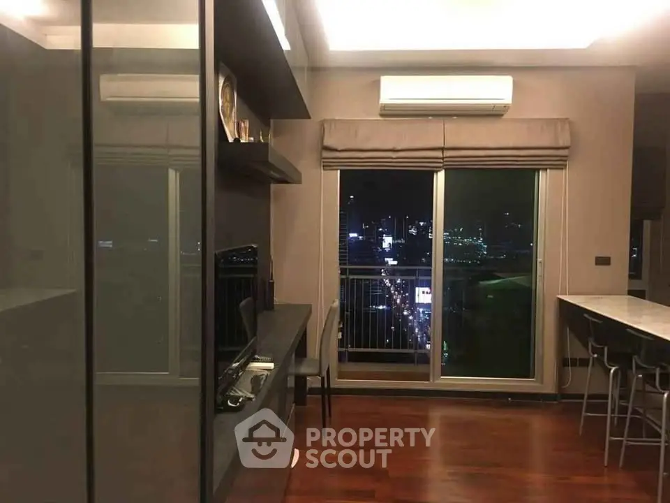 Modern apartment interior with city view, featuring sleek design and hardwood floors.