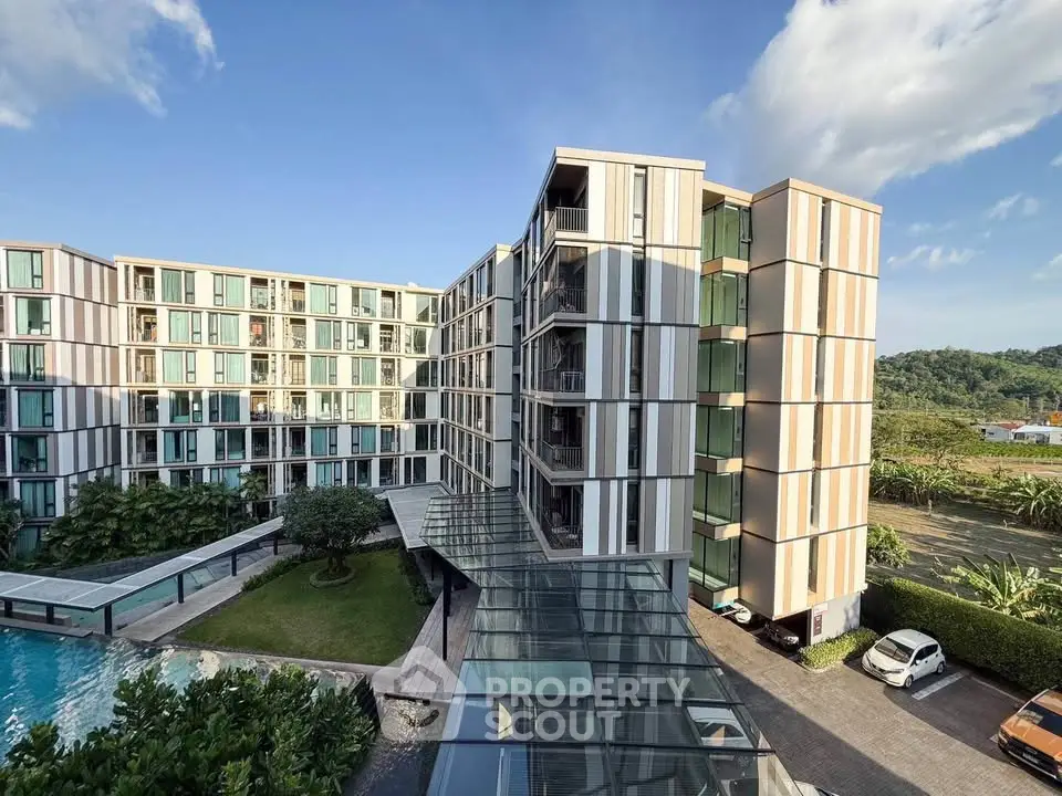 Modern apartment building with pool and lush greenery, offering scenic views and contemporary design.