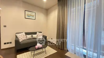 Cozy living room with elegant sofa and floor-to-ceiling curtains, perfect for relaxation.