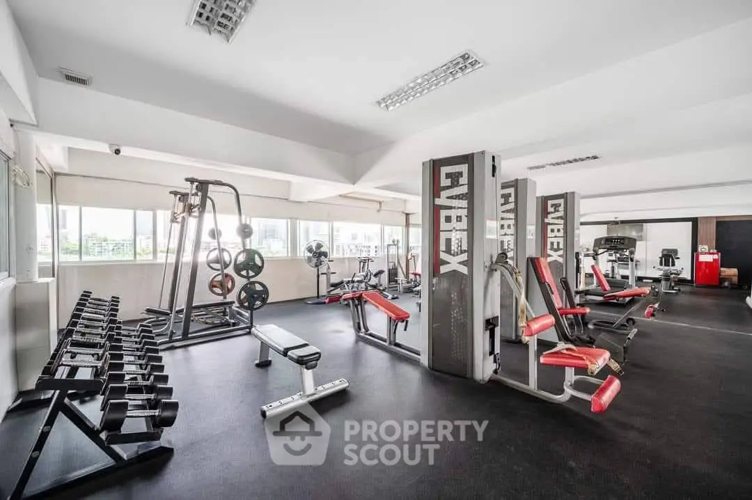 Spacious and modern gym with state-of-the-art fitness equipment and ample natural light.