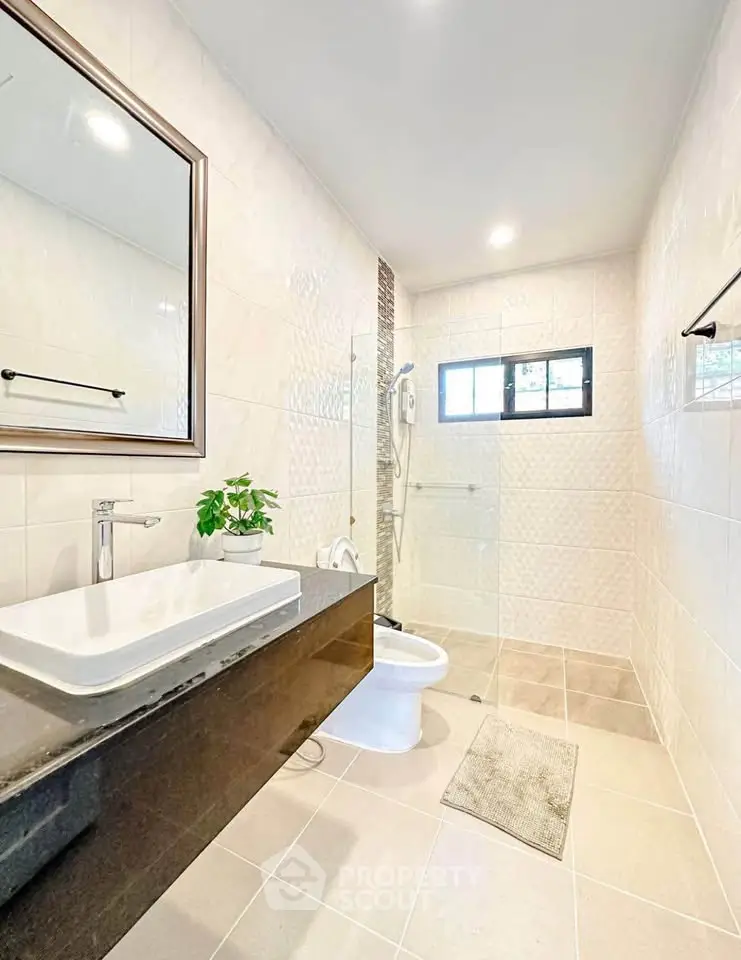 Modern bathroom with sleek fixtures and glass shower enclosure