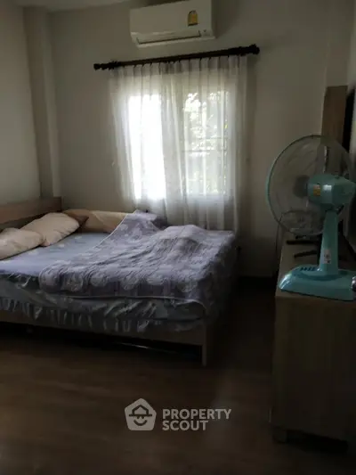 Cozy bedroom with wooden flooring and natural light