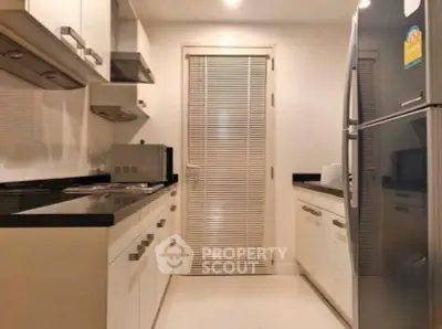 Modern kitchen with sleek cabinetry and stainless steel appliances in a contemporary apartment.