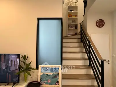 Modern interior with stylish staircase and cozy living area, perfect for contemporary living.