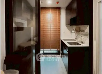 Modern compact kitchen with sleek cabinetry and window blinds