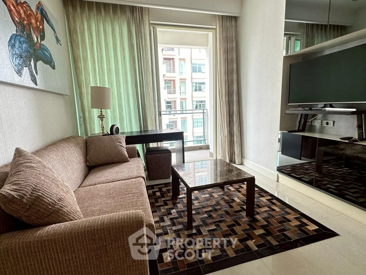 Stylish modern living room with large TV and balcony view in urban apartment.