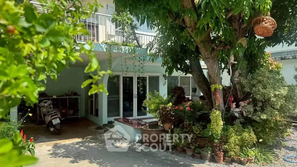 Charming house exterior with lush garden and spacious driveway, perfect for nature lovers.