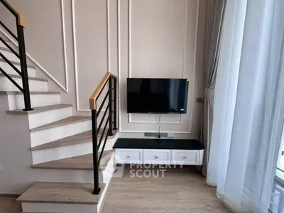 Modern living room with stylish staircase and wall-mounted TV