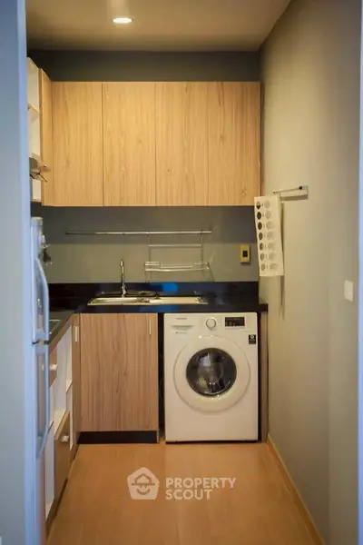 Modern compact kitchen with wooden cabinets and built-in washing machine
