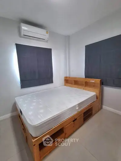 Cozy bedroom with modern air conditioning and stylish wooden bed frame, perfect for restful nights.