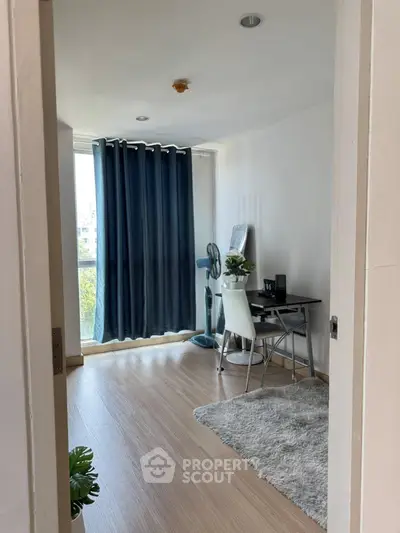 Modern study room with natural light, wooden flooring, and stylish decor in a contemporary apartment.