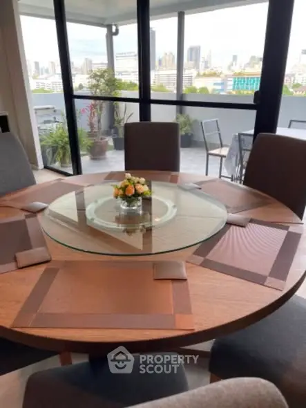 Elegant dining area with city view from spacious balcony, perfect for entertaining guests.