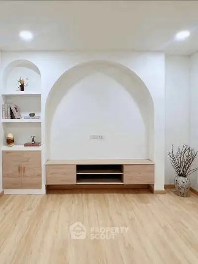 Modern minimalist living room with built-in shelves and wooden flooring