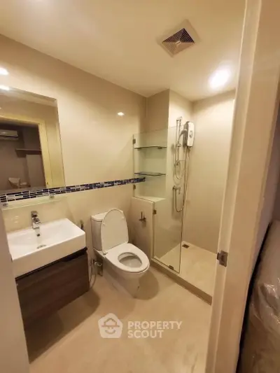 Modern bathroom with glass shower and sleek fixtures in a contemporary apartment.