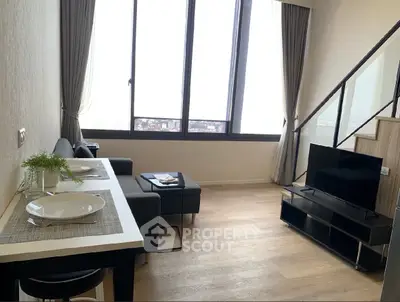 Modern living room with large windows and stylish decor in a high-rise apartment