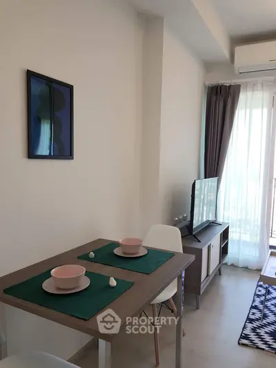 Modern dining area with stylish table setting and TV, perfect for cozy living.