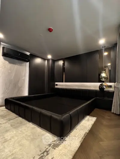 Luxurious modern bedroom with sleek black leather bed and elegant lighting