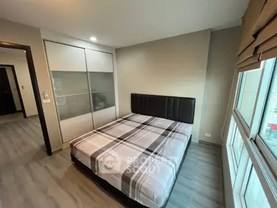 Modern bedroom with large windows and stylish decor in a high-rise apartment.