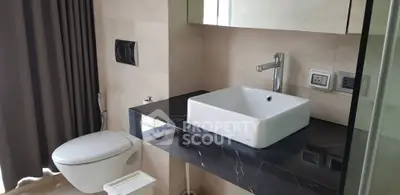 Modern bathroom with sleek black countertop and square sink