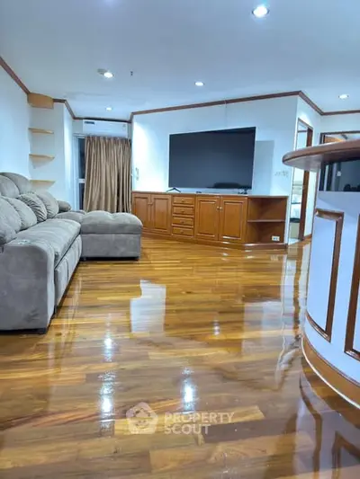Spacious living room with polished wooden floors and modern furnishings