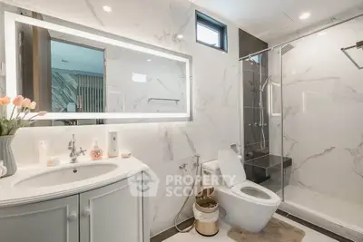 Luxurious modern bathroom with elegant marble finish and spacious shower area.